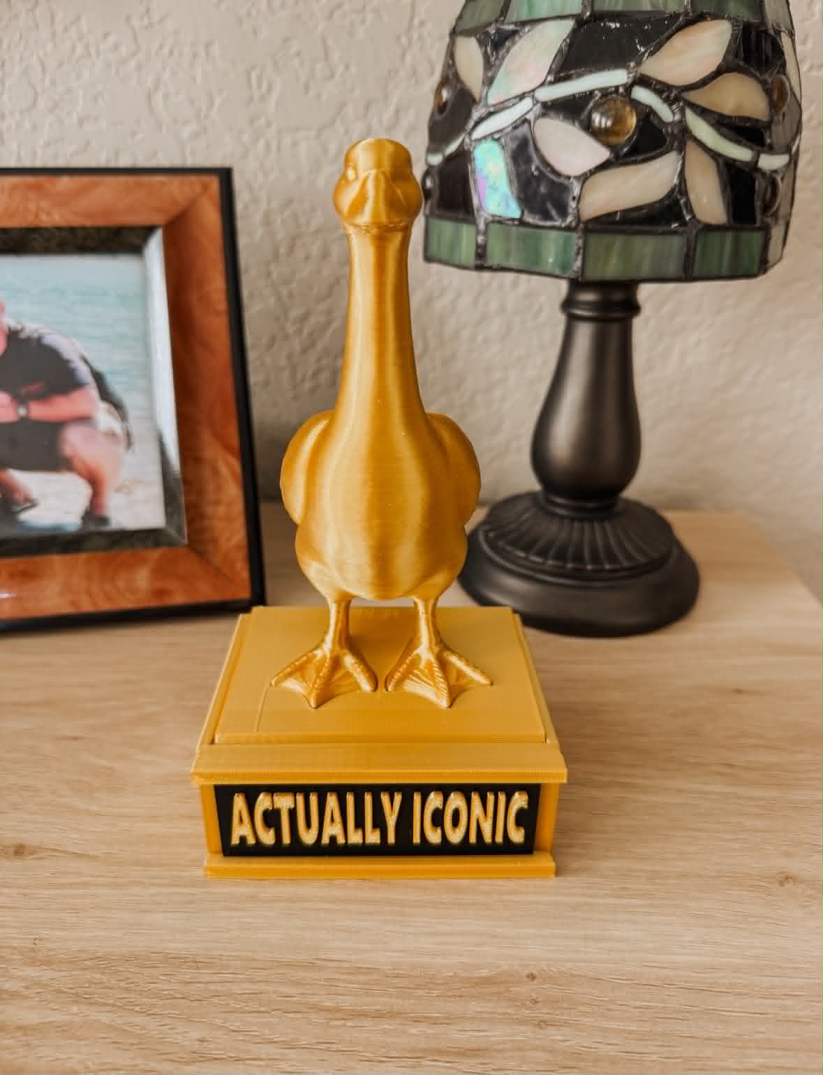 Golden Goose trophy on a platform with a 'Actually Iconic' sign 